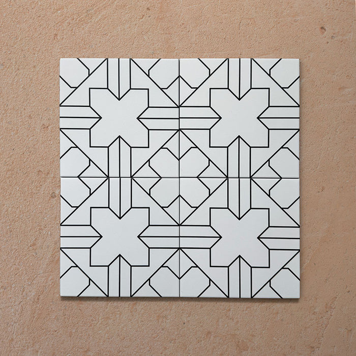 Alhambra Palacio 20x20cm Moroccan tiles arranged in a 4-tile layout, showcasing a bold black geometric cross motif on a white base for a clean, modern Moroccan design.
