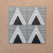Alhambra Pyramid 20x20cm Moroccan tiles arranged in a four-tile layout, featuring bold black and white triangular patterns with fine horizontal lines for a modern geometric effect.