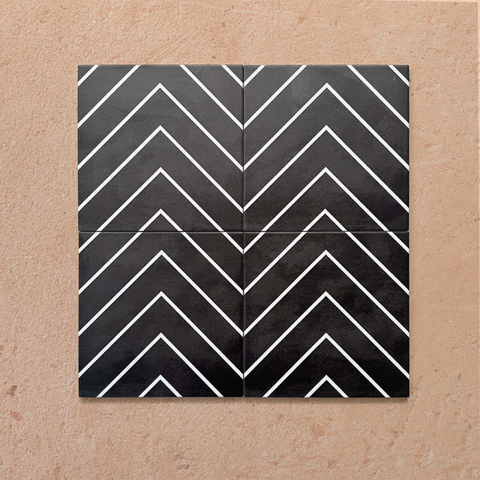 Alhambra Zig Zag Black 20x20cm Moroccan tiles arranged in a four-tile layout, displaying bold black chevron stripes with crisp white lines for a striking geometric effect.