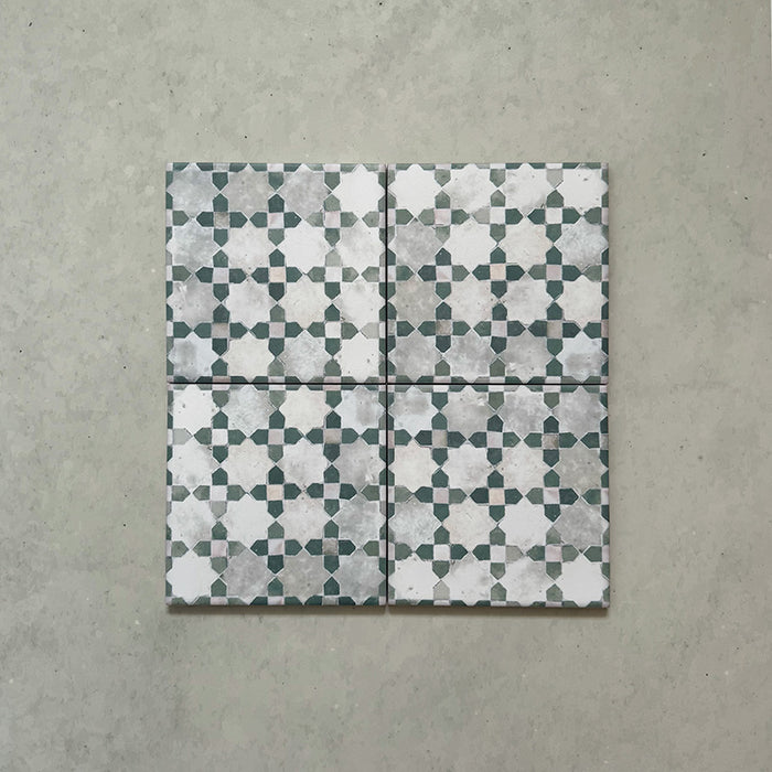 Bedouin Mequinez Green Moroccan-style 15x15cm tiles shown as a set of four, featuring a geometric star and cross design in soft green, grey, and white tones with a handcrafted aged finish.