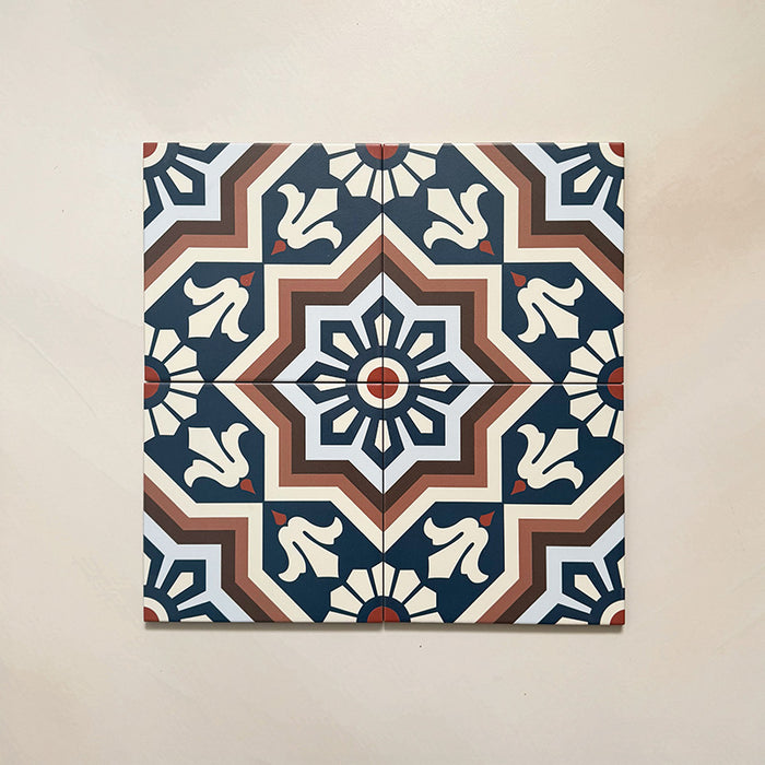 Four Brompton Grand 20x20cm Victorian-Moroccan-style ceramic tiles displayed together, featuring a symmetrical star and floral pattern in navy blue, terracotta, cream, and white tones on a light beige background.