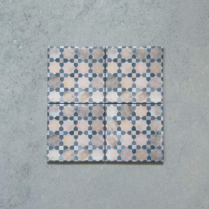 Four Bedouin Mequinez Blue Moroccan-style ceramic tiles, 15x15cm each, arranged to display the repeating geometric star and cross pattern in soft blue, beige, and cream tones on a textured surface background.