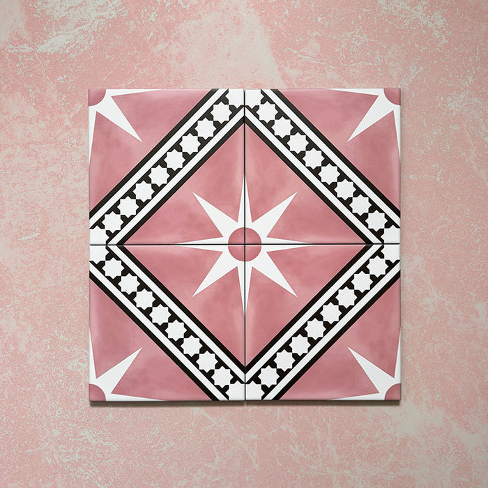 Galata Pink Moroccan Style 20x20cm four-tile layout featuring a bold geometric star and diamond motif in blush pink, white, and black with a smooth matt finish, displayed on a textured pink background.