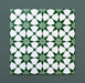 Four Agraba Green 20x20cm Moroccan-style ceramic tiles arranged together to show the seamless geometric star pattern in deep and soft green tones with white detailing on a dark green background.
