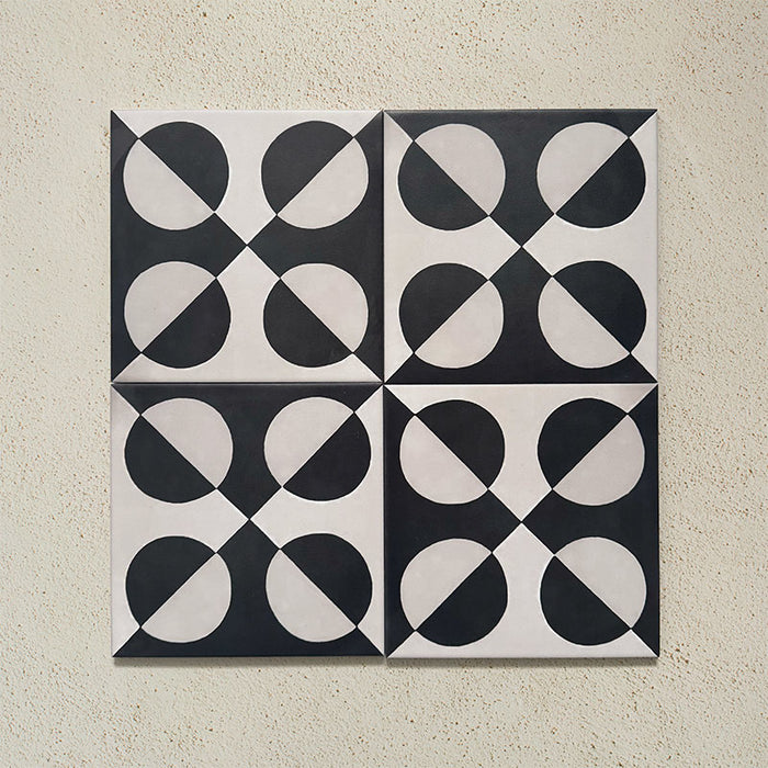 Group image showing four Geometry Illusion Noir 20x20cm geometric patterned tiles arranged to create a symmetrical circular repeat, featuring bold black and cream semicircles, photographed against a textured neutral background.