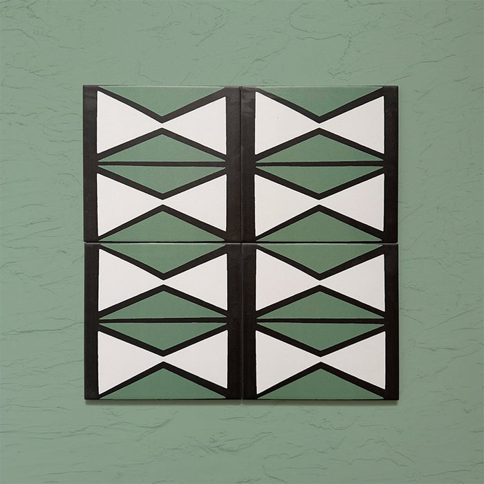 Group image showing four Geometry Hourglass 20x20cm patterned tiles arranged in a repeating vertical design, featuring alternating green and cream hourglass shapes outlined in charcoal, photographed against a textured sage-green background.