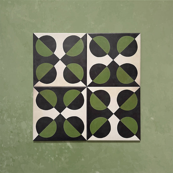 Group image showing four Geometry Illusion Verde Noir 20x20cm geometric patterned tiles arranged to create a circular repeat, featuring green and black semicircles with cream diamond intersections, photographed against a mottled green background.