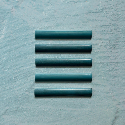 Zellij Peacock Green bullnose tile, 3cm x 20cm, Moroccan style glazed ceramic trim in deep peacock green tones with subtle tonal variation, glossy finish, smooth rounded profile, and handcrafted-inspired surface texture, shown as a set of bullnose pieces on a pale textured background.