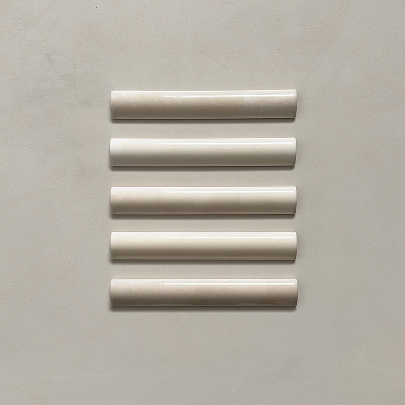 Zellij Bone bullnose tile in a 3cm x 20cm format, Moroccan style, featuring soft bone-beige tones, a glossy finish, and gentle handmade surface variation, shown as a flat lay of five trims on a neutral background.