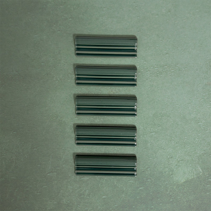 Flat lay of Finchley Golders Green ceramic dado trim tiles in a 5 × 15cm format, featuring a crackle glaze finish that adds depth, texture and a decorative, classic detail to wall tile designs.