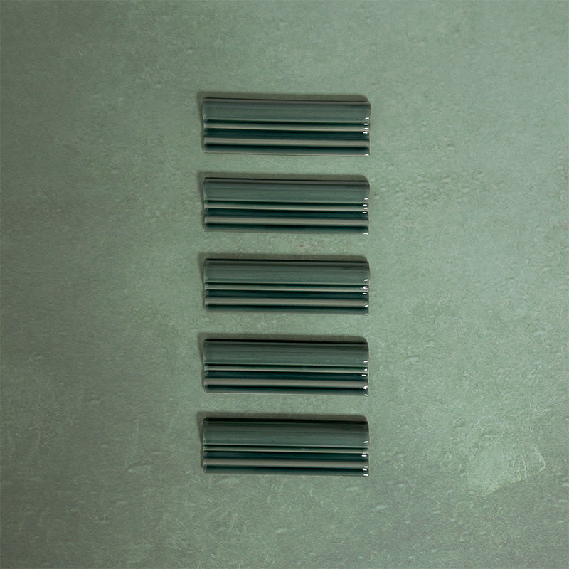 Flat lay of Finchley Golders Green ceramic dado trim tiles in a 5 × 15cm format, featuring a crackle glaze finish that adds depth, texture and a decorative, classic detail to wall tile designs.