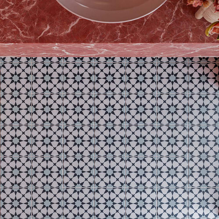 Agraba Azul Blue 20cm x 20cm Moroccan style floor tiles, showcasing a repeating blue and white geometric star pattern alongside a statement pink marble vanity.