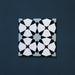 Close-up of Agraba Azul Blue 20x20cm Moroccan-style ceramic tile featuring a geometric star pattern in navy, light blue, and white tones on a deep blue background.