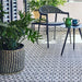 Outdoor terrace featuring Agraba Black and White 20x20cm Moroccan-style ceramic floor tiles, styled with navy furniture and large potted green plants.