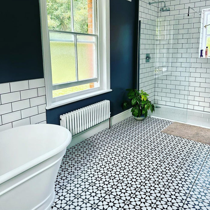 Bathroom featuring Agraba Black and White 20x20cm Moroccan-style ceramic floor tiles, with navy walls, white metro tiles, and chrome bathroom fixtures.