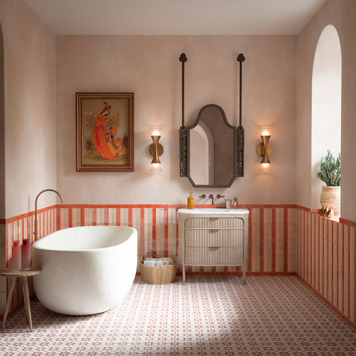 Bathroom featuring Agraba Cotto 20cm x 20cm Moroccan-style floor tiles, paired with striped terracotta wall tiles, a freestanding bath, neutral walls and warm brass details.