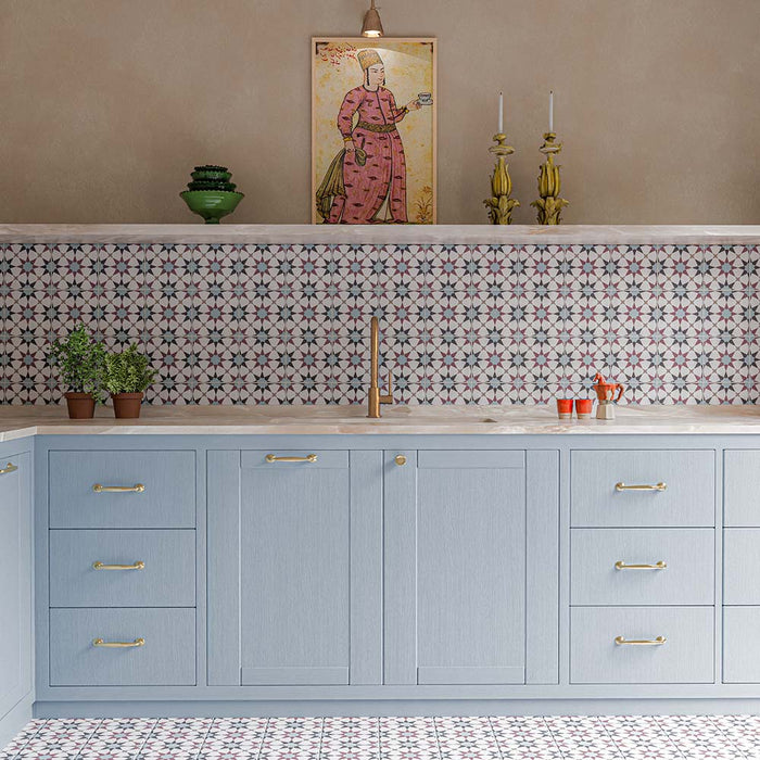 Agraba Mini Atlas 15cm x 15cm Moroccan style tiles, featuring a repeating geometric pattern in soft blue, burgundy and white across the kitchen splashback and floor, paired with pale blue cabinetry and brass details.