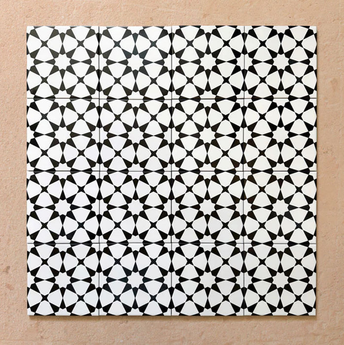 Close-up of multiple Agraba Black and White Mini 15x15cm Moroccan-style ceramic tiles arranged in a grid, showcasing their bold geometric star pattern and smooth matt surface on a neutral background.