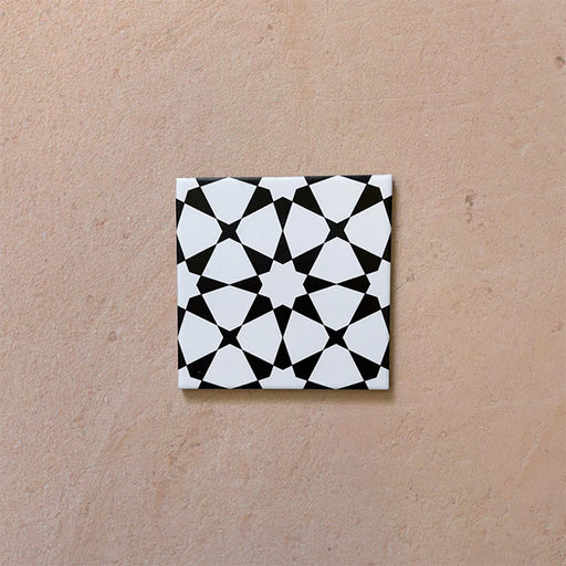 Close-up of Agraba Black and White Mini 15x15cm Moroccan-style ceramic tile featuring a bold geometric star pattern in black and white on a neutral background.