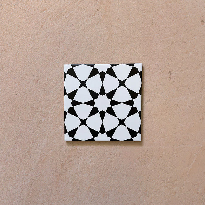 Close-up of Agraba Black and White Mini 15x15cm Moroccan-style ceramic tile featuring a bold geometric star pattern in black and white on a neutral background.