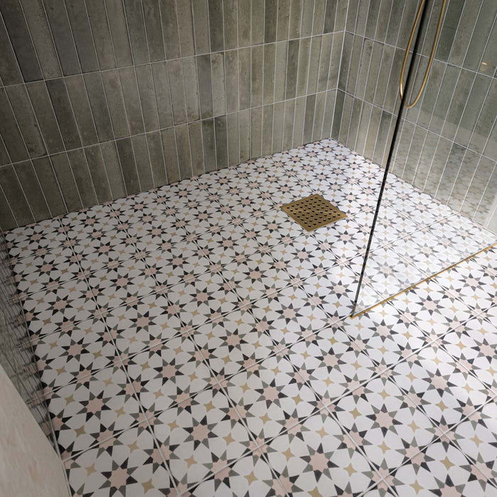 Walk-in shower featuring Agraba Natural Moroccan style patterned floor tiles, paired with sage green vertically laid wall tiles, a frameless glass shower screen and brushed brass shower fittings for a contemporary, Mediterranean-inspired bathroom.