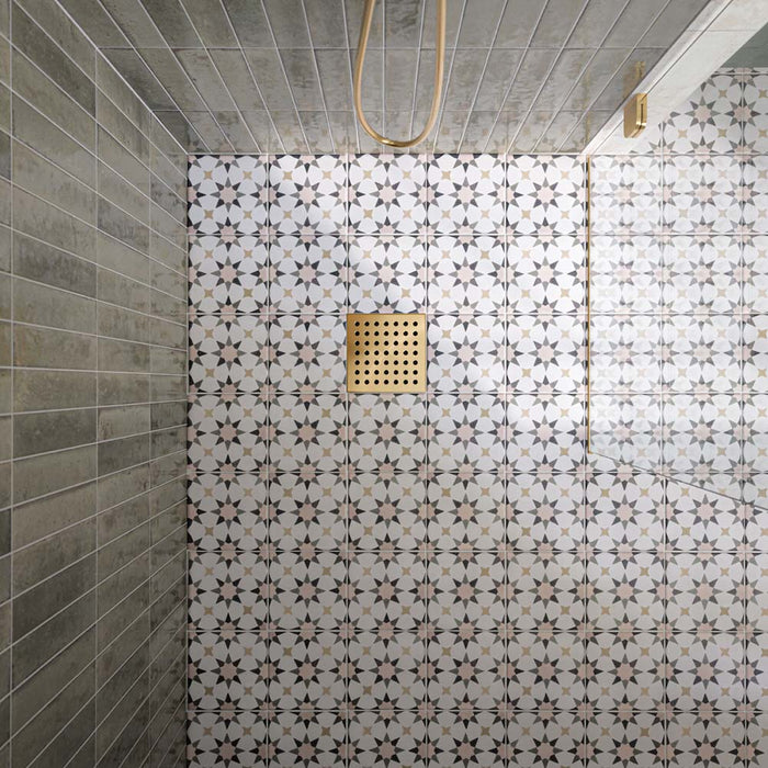 Walk-in shower featuring Agraba Natural Moroccan style patterned floor tiles, paired with sage green vertically laid wall tiles, a frameless glass shower screen and brushed brass shower fittings for a contemporary, Mediterranean-inspired bathroom.