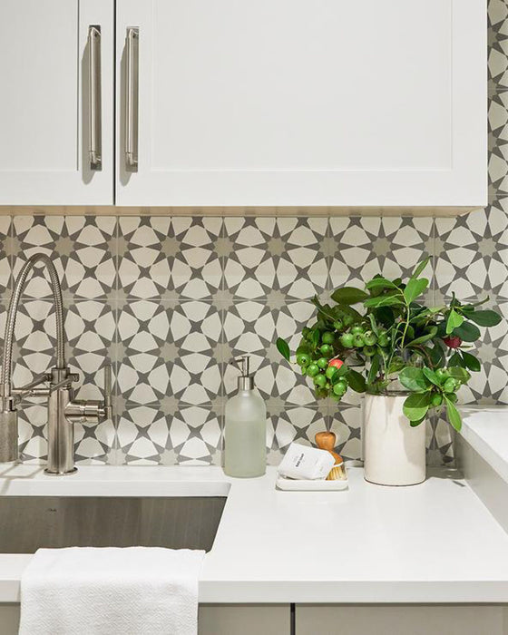 Kitchen featuring Agraba Silver 20cm x 20cm patterned splashback tiles, with a geometric star design in soft grey and white, paired with white cabinetry, worktops and brushed metal fixtures.