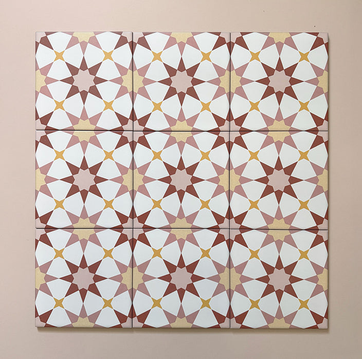 Close-up of multiple Agraba Springs 20x20cm Moroccan-style ceramic tiles arranged in a grid, featuring a geometric star pattern in terracotta, blush pink, mustard, and white tones on a soft pastel background.