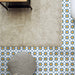 Living room featuring Agraba Sunshine 20x20cm Moroccan-style ceramic floor tiles with a geometric star pattern in blue, mustard, and white tones, styled with a neutral rug and textured pouffe for a warm Mediterranean look.