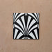 Alhambra Casa 20x20cm Moroccan tile featuring a bold black and white fan-shaped geometric pattern on a terracotta-toned background, perfect for creating elegant Art Deco-inspired interiors.