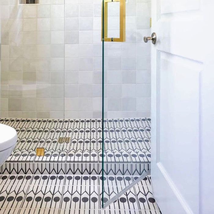 Alhambra Felisa 20x20cm Moroccan tiles used in a walk-in shower, featuring a striking black and white geometric pattern paired with neutral wall tiles and gold accents for a clean, contemporary Moroccan style.