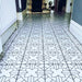 Alhambra Palacio 20x20cm Moroccan tiles used in a hallway, featuring a detailed black geometric cross pattern on a white background for a refined, statement floor design.