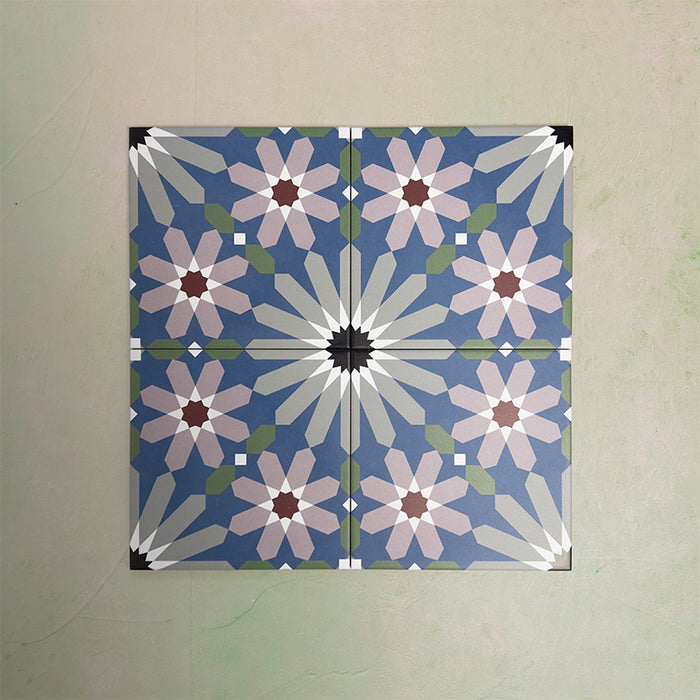 Fizaan Artisan Moroccan-style 20×20cm porcelain tiles laid in a repeating geometric pattern, featuring blue, green and soft pink star motifs.