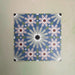 Fizaan Artisan Moroccan-style 20×20cm porcelain tiles laid in a repeating geometric pattern, featuring blue, green and soft pink star motifs.