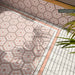 Outdoor tiled area featuring Atlas Pink Mini Brick Matt 5cm x 15cm tiles used as a soft pink border around Moroccan style hexagon patterned tiles, creating a coordinated decorative floor design.