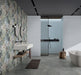 Bathroom featuring Barbados 60 × 120cm wall tiles, creating a full-height botanical feature wall with layered tropical detail. Paired with minimalist fittings and concrete-effect flooring for a clean, contemporary contrast.