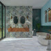 Bathroom featuring Barbados 60cm x 120cm wall and floor tiles with a botanical leaf design, paired with blue herringbone tiles, a freestanding bath, wooden vanity and brass details.