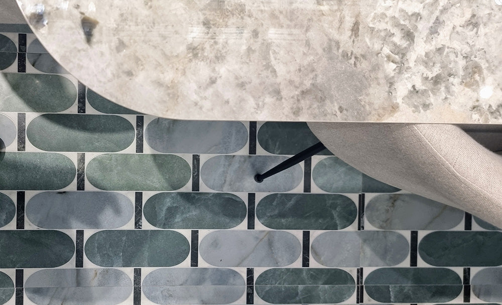 Close-up of Bassano Abacus 3D Décor 60 × 120cm patterned wall and floor tiles, featuring geometric rounded shapes in soft green and marble-effect tones, paired with contemporary furniture and stone-effect surfaces.