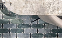 Close-up of Bassano Abacus 3D Décor 60 × 120cm patterned wall and floor tiles, featuring geometric rounded shapes in soft green and marble-effect tones, paired with contemporary furniture and stone-effect surfaces.