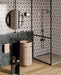 Bathroom interior featuring Bassano Flowers 3D Décor 60 × 120cm patterned wall and floor tiles, paired with a walk-in shower, blush pink basin, dark fittings, and textured green wall tiles for a contemporary statement look.