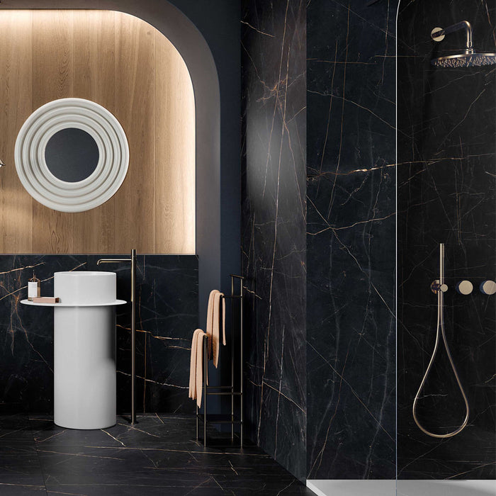 Luxury bathroom featuring Bassano Precious Noir Lux 3D 60 × 120cm marble-effect wall and floor tiles, paired with brass fittings, a walk-in shower, warm wood accents, and contemporary sculptural bathroom furniture.