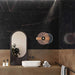 Bathroom interior featuring Bassano Precious Noir Lux 3D 60 × 120cm marble-effect wall and floor tiles, styled with warm bronze tones, contemporary black fittings, sculptural mirror, and elegant gold veining throughout.