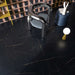 Interior featuring Bassano Precious Noir Lux 3D 60 × 120cm marble-effect wall and floor tiles, styled with sculptural furniture, deep black tones, and striking gold veining for a bold contemporary luxury setting.