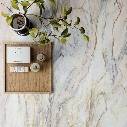 Close-up of Bassano Quartz Lux 3D 60 × 120cm marble-effect wall and floor tiles, featuring flowing white, grey, and gold veining, styled with warm wood accents and contemporary decorative accessories.