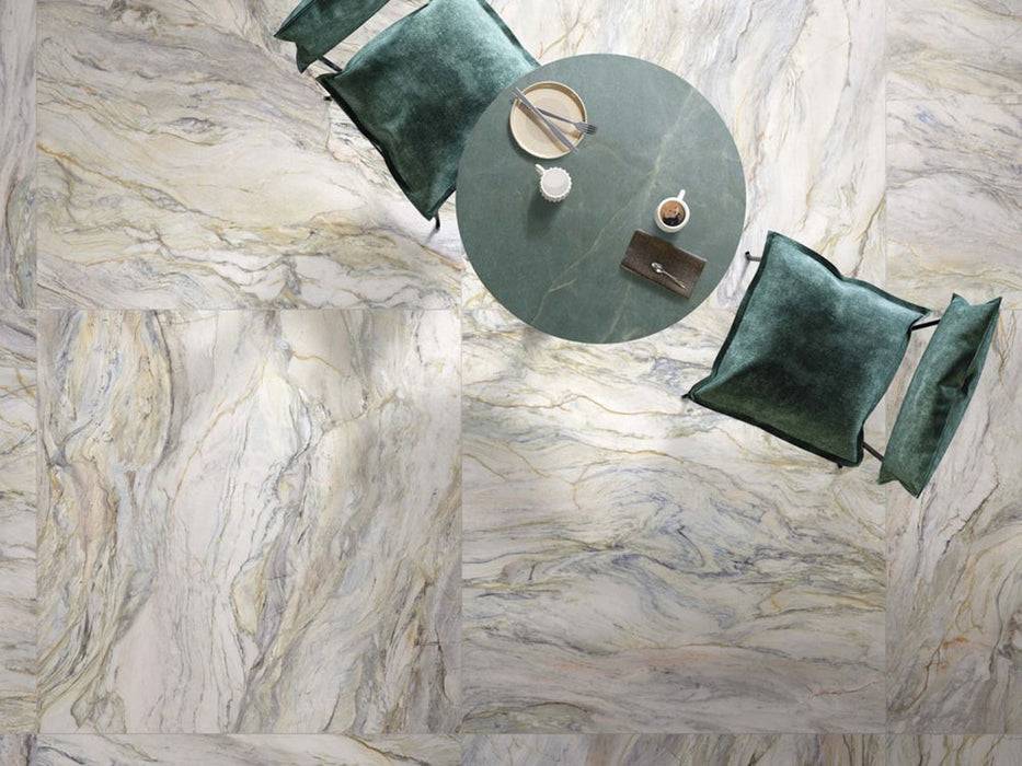 Overhead view featuring Bassano Quartz Lux 3D 60 × 120cm marble-effect wall and floor tiles, styled with soft green furnishings, flowing grey and gold veining, and contemporary furniture for a luxurious interior setting.