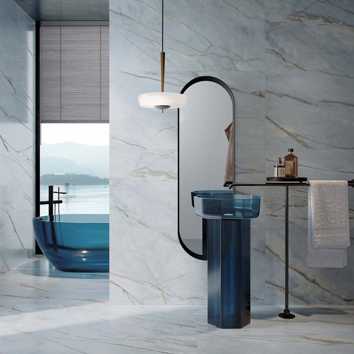 Bathroom interior featuring Bassano River Blue Lux 3D 60 × 120cm marble-effect wall and floor tiles, styled with soft blue veining, a translucent blue basin and bathtub, black fittings, and contemporary lighting for a calm, luxurious atmosphere.