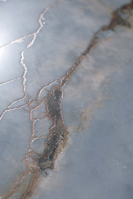 Close-up of Bassano River Blue Lux 3D 60 × 120cm marble-effect wall and floor tiles, showcasing soft blue tones, shimmering metallic-style veining, and a polished surface with intricate natural stone-inspired detailing.