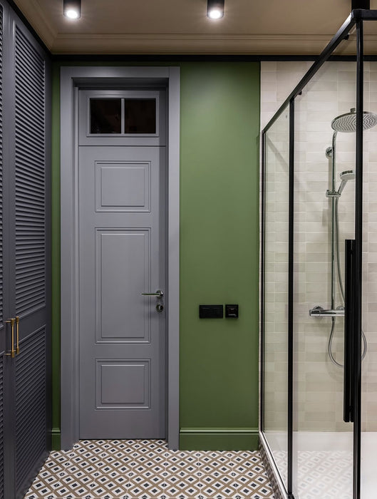 Bathroom featuring Carnaby Park Road 20x20cm Victorian style wall and floor tiles, showcasing a geometric patterned floor in neutral tones, paired with green walls, a wood vanity unit, and modern black-framed shower enclosure.