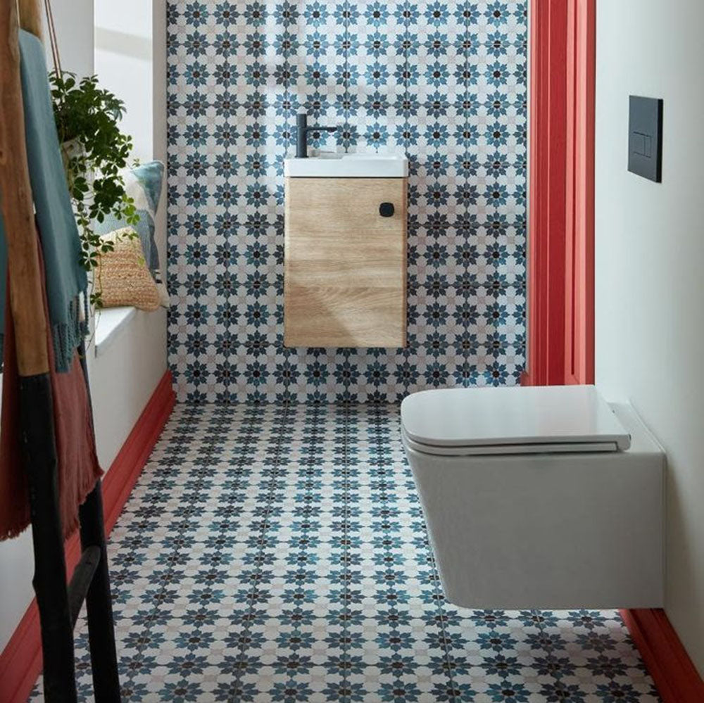 Bathroom interior featuring Mamounia River 20 x 20cm Moroccan style wall and floor tiles in blue and white tones, creating a cohesive patterned scheme, styled with a floating wood vanity, matte black brassware, and warm natural textures for a balanced, characterful space.