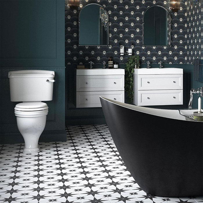 Bathroom setting featuring Pole Star Black Moroccan-style 25x25cm patterned porcelain floor tiles, creating a bold geometric look beneath twin white vanity units and dark cabinetry.